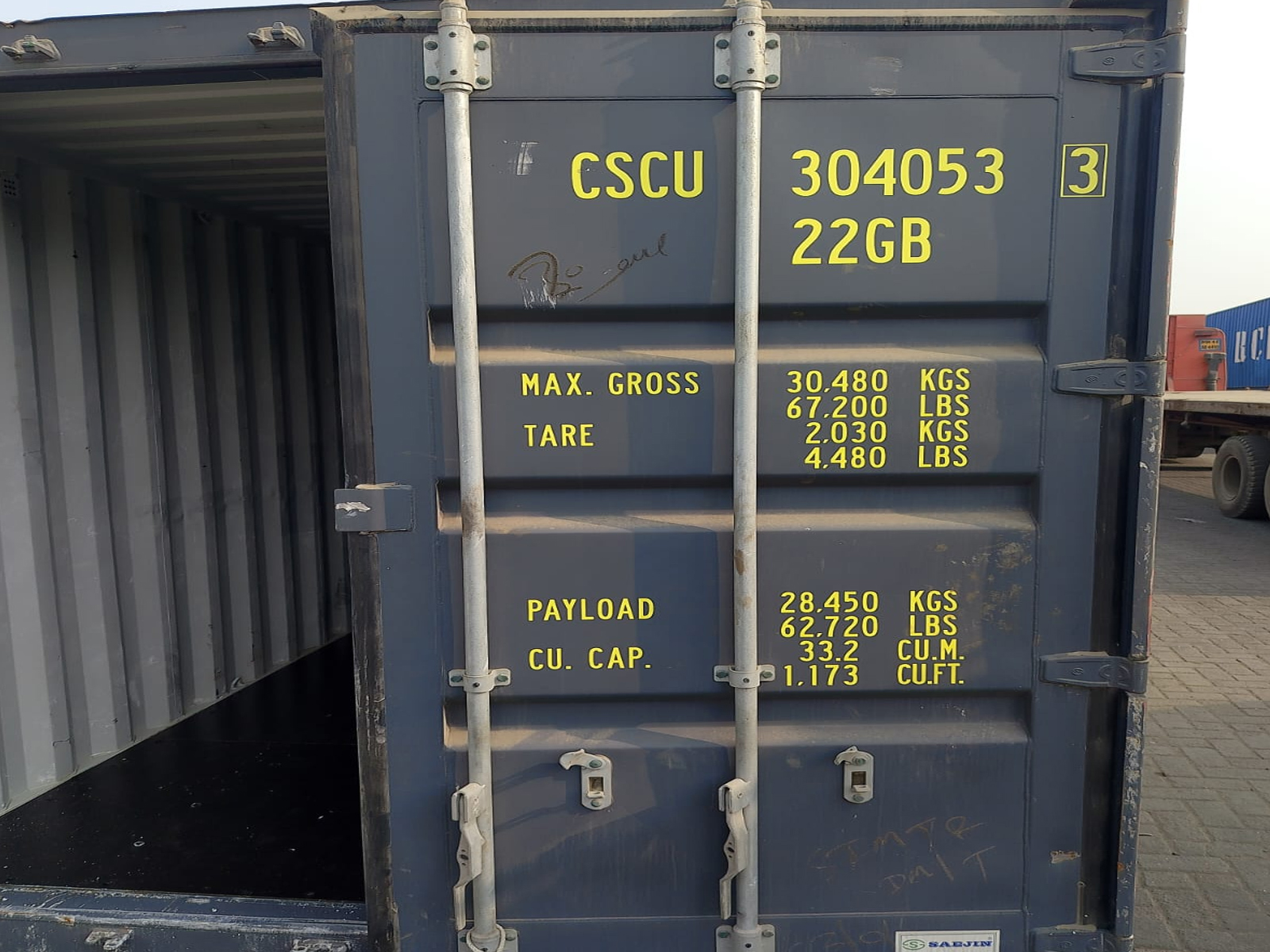 Close-up of a blue intermodal shipping container door with weight specifications and CSCU markings.